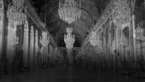 black and white image of a very grand hall with chandeliers